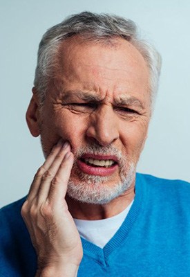 Man rubbing his aching jaw