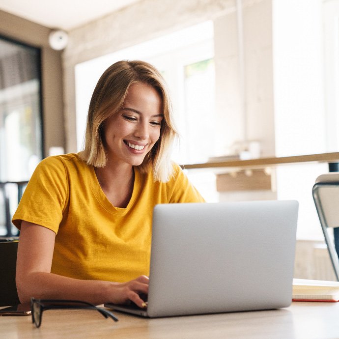 Woman in yellow shirt smiling at work