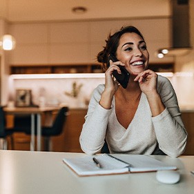 Woman smiling while talking on phone in kitchen