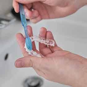 Patient cleaning aligners in sink